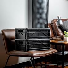 Two black SIDIO crates stacked on top of a leather chair